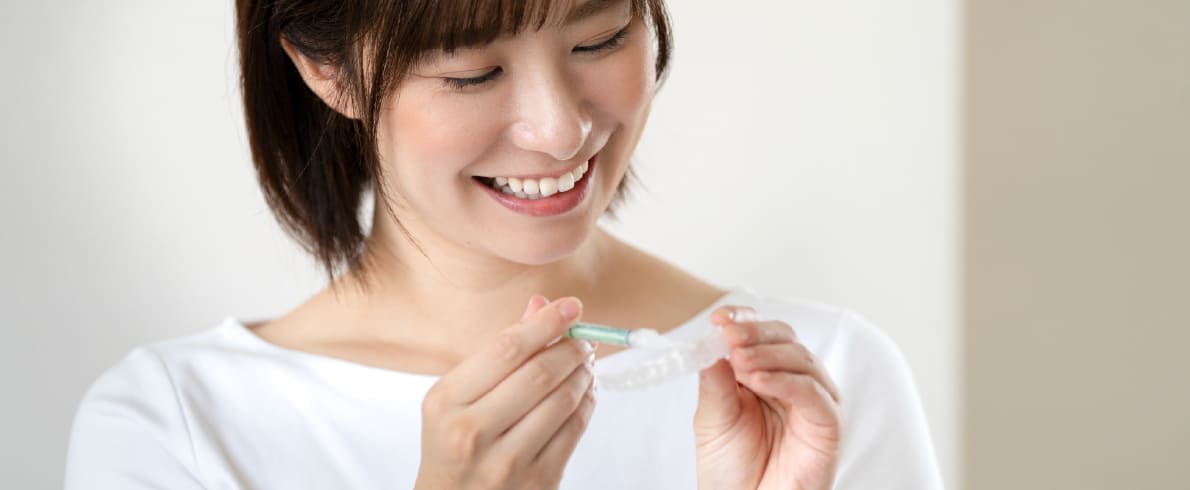 ホームホワイトニング用のマウスピースを持つ女性